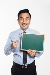 Man in office wear poiting towards a black board