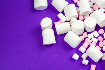 marshmallow laid out on violet paper background.