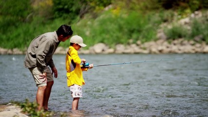 Happy Caucasian son learning fishing with father on Colorado River on holiday