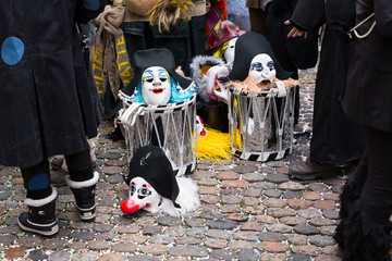 Basel carnival 2018. Andreasplatz, Basel, Switzerland - February 19th, 2018. Close-up of a pile of carnival masks and snare drums on confetti covered cobble stones
