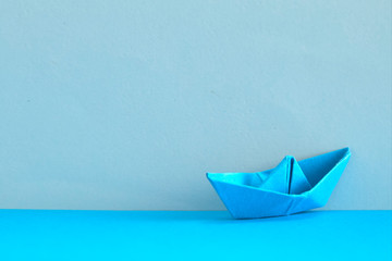 Blue Paper boat on cyan background