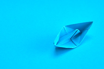 Fototapeta premium Blue Paper boat on cyan background
