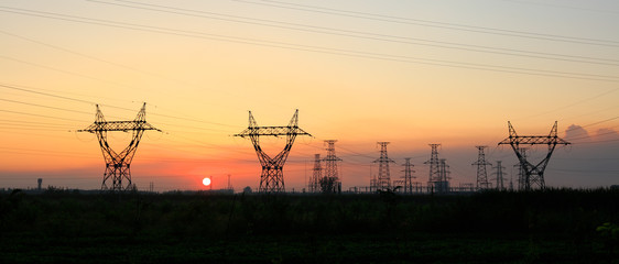 In the evening, the silhouette of high voltage towers
