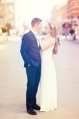 Naklejka premium Romantic wedding of bride and groom celebrating marriage in the autumn in city.