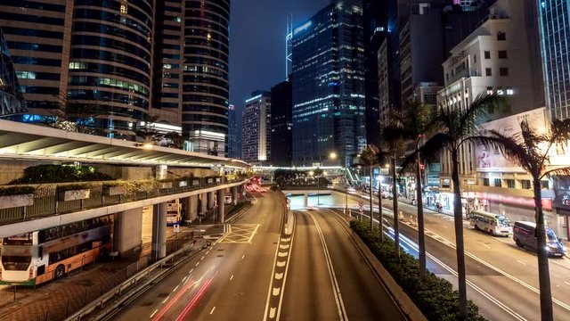 Hong Kong city traffic after sunset. Illuminated street and skyscrapers in Hong Kong at night