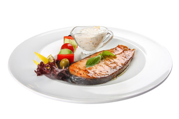 Fototapeta na wymiar Salmon steak with vegetables and sauce. On a white background