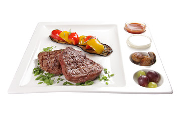 Pork steak with sauces and vegetables. On a white background