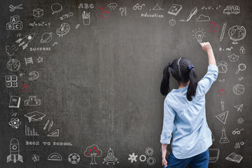 Elementary school kid student drawing doodle on black chalkboard with child's imagination for...