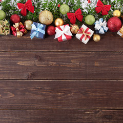 Christmas decorations and gift boxes on wooden board background square