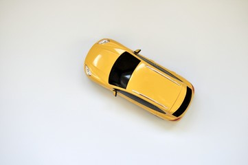 Toy yellow car on white background. top view, flat lay, copy space
