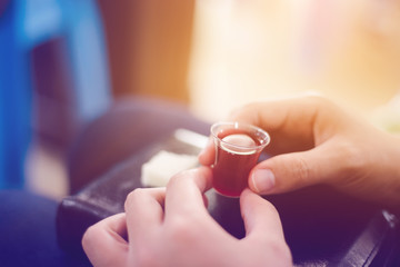 Soft focus Hands hold a red wine cup in Holy communion concept.