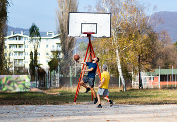 Obraz premium Father and son playing basketball in the park