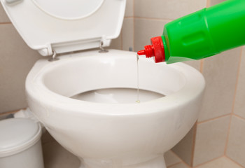 Disinfectant being poured in toilet bowl.