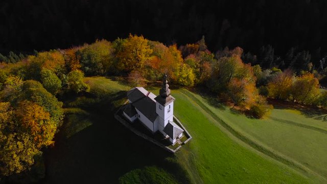 4K aerial drone footage flying around chapel in Danje,Slovenia with mountains in background