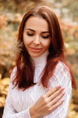 Fototapeta premium woman in dress and hat on background of autumn foliage