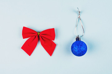 Red tied bow and christmas ball on blue background