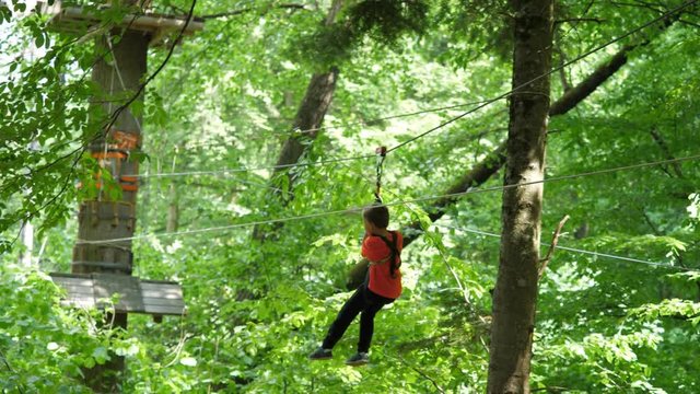 Brave child at adventure park, little boy on flying fox, extreme sport