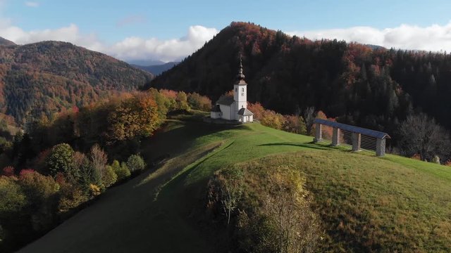 4K aerial drone footage flying around chapel in Danje,Slovenia with mountains in background