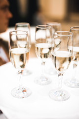 Waiter serving glasses with champagne on a tray