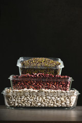 White beans, red beans mung bean in glass bowls on a dark background. Eco friendly, plastic free items.