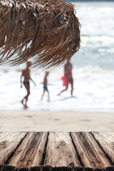 Straw umbrella on the beach. Straw umbrella on an tropical beach, selective focus, sea blurred background.Summer background