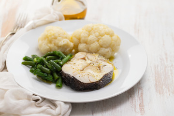 boiled fish with boiled vegetables on white plate