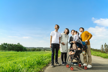 Obraz premium 妊娠している夫婦が既に子供2人居る友人と遠くを見上げている様子。