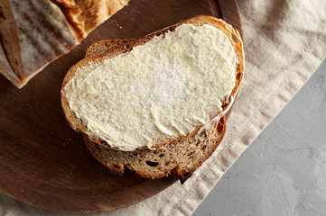 Artisan sliced toast bread with butter and sugar on wooden cutting board