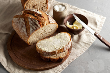 Artisan sliced toast bread with butter and sugar on wooden cutting board