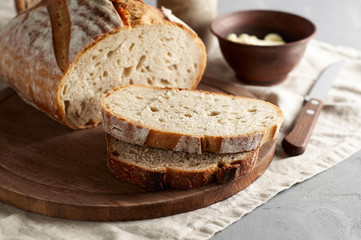 Artisan sliced toast bread with butter and sugar on wooden cutting board