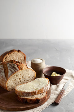 Artisan sliced toast bread with butter and sugar on wooden cutting board