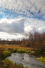 Dry grass and small lake on the field in sunny autumn day