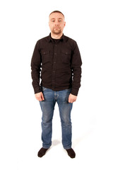 Fototapeta premium A young man dressed in jeans and a black shirt standing on white background