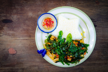 fried rice with basil on old wood background.