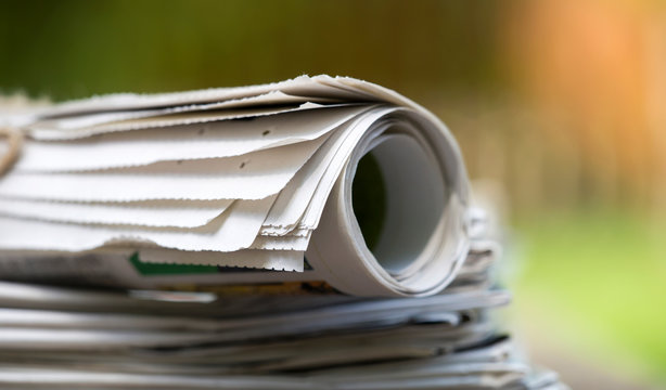 Business, daily news concept - stack of newspapers close-up