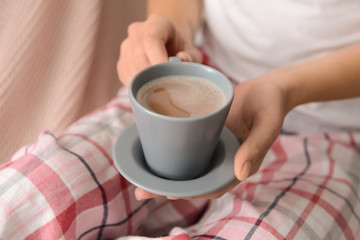 Woman drinking aromatic coffee in bed, closeup