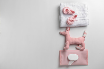 Soft towels, toy and baby shoes on white background