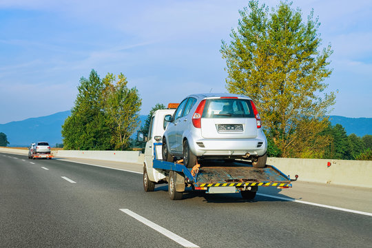 Tow truck transporter carrying car in Road in Slovenia