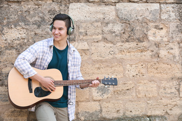 Young man playing guitar outdoors