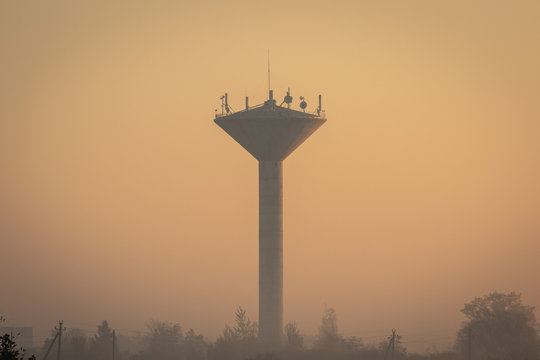 Water tower covered in mist during moody autumn morning. Joniskis, Lithuania.