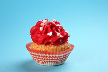 Tasty cupcake on color background