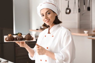 Young female chef with tasty dessert in kitchen