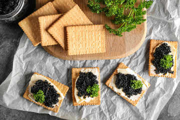 Cookies with delicious black caviar on parchment