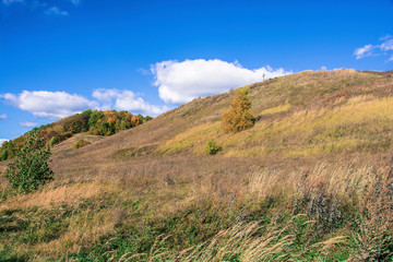 Fototapeta na wymiar Bright autumn landscape with a cross on a mountain on a sunny day.