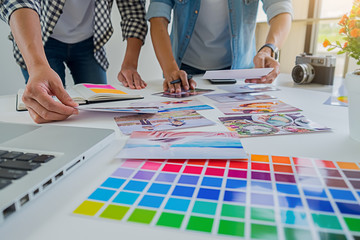 Asian advertising designer creative start-up team discussing ideas in office.