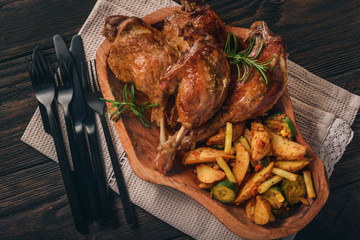 Roasted duck legs with apples and cranberries, served with vegetables.