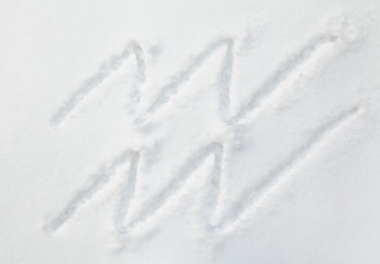 Sign of zodiac Aquarius on white snow
