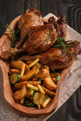 Roasted duck legs with apples and cranberries, served with vegetables.