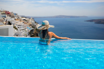 Woman enjoying relaxation in pool and looking at the view