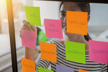 Web designer brainstorming for a strategy plan. Colorful sticky notes with things to do on office...
